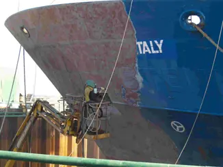 Before and after grit blasting a ship hull